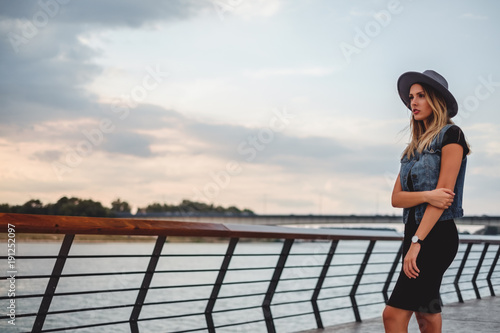 Hipster girl watching sunset by the river alone
