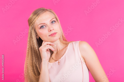 Studio portrait of beautiful young woman thinking and looking at camera.