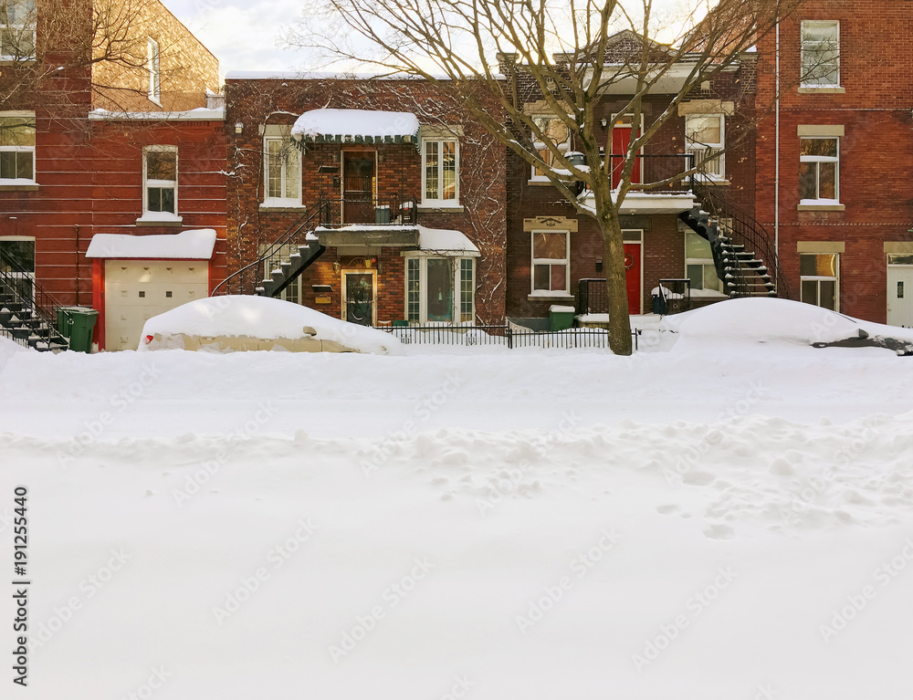 Fototapeta premium Snowy urban street with brick buildings