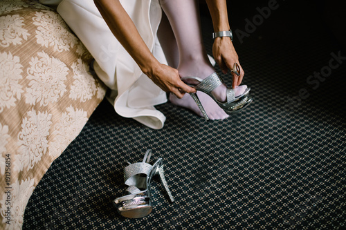 Bride in the dress in the white bridal shoes
