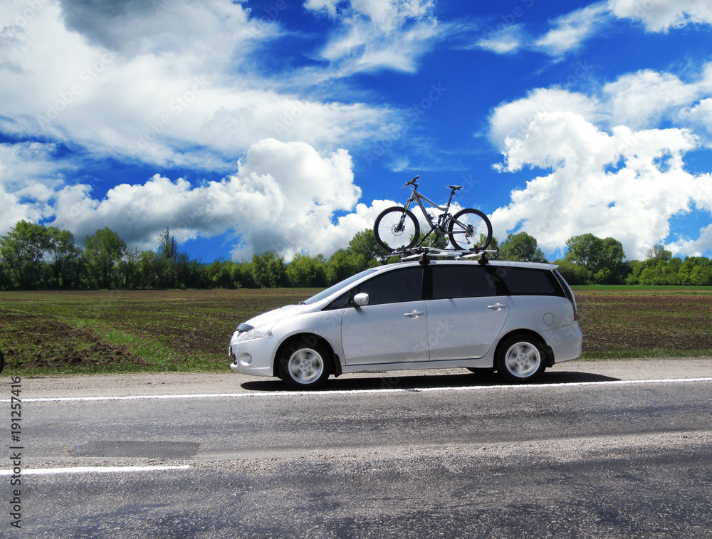 Car with the bycycle on the highway