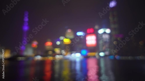 Abstract blurred background with skyscrapers of a big city and luminous advertising signs are reflected in the water