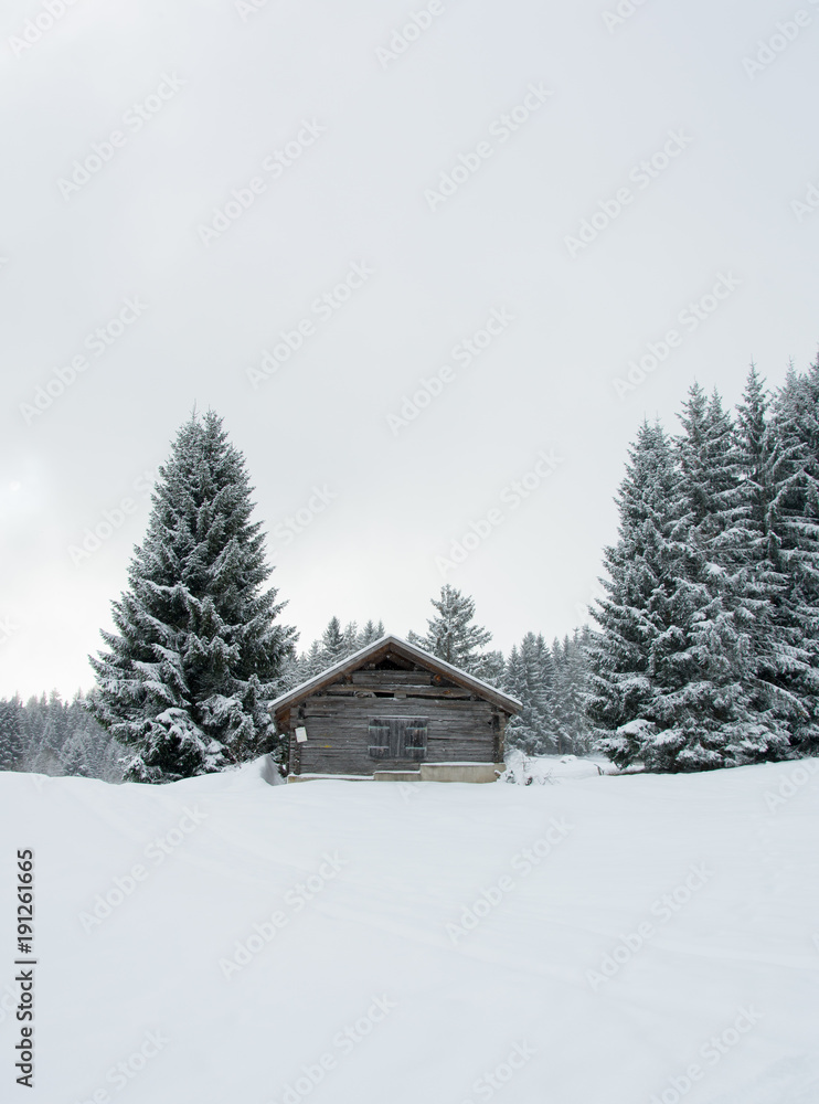 Berghütte zwischen verschneiten Tannen Berghütte zwischen verschneiten Tannen
