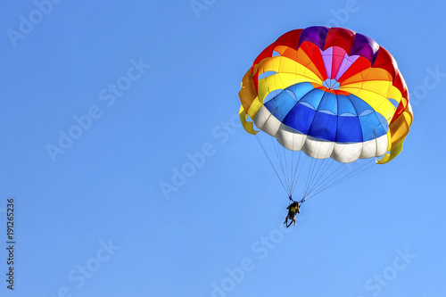Photo Two men are gliding using a parachute on the background of the blue sky