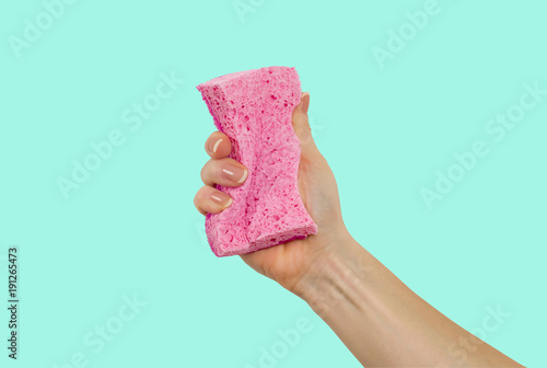 Woman's hand, holding a sponge for dishes