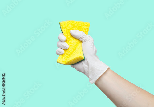 Hand in glove holding sponge for dishes
