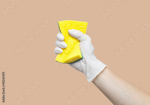 Hand in glove holding sponge for dishes