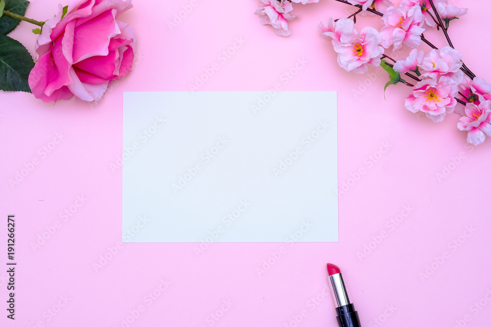 Set of makeup brushes, decorative cosmetics and flowers on pink colored composed background. Top view point, flat lay, space for text