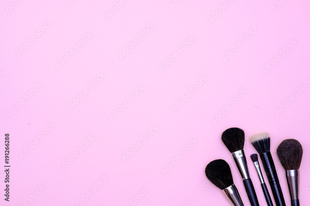 Set of makeup brushes on pink colored composed background. Top view point, flat lay, space for text Set of makeup brushes on pink colored composed background. Top view point, flat lay, space for text