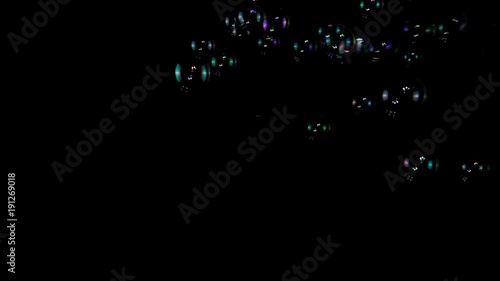 Colorful soap bubbles in slow motion on a black background