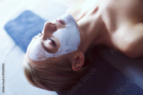 Face mask.Beautiful young girl at spa ,cosmetician woman applying facial mask