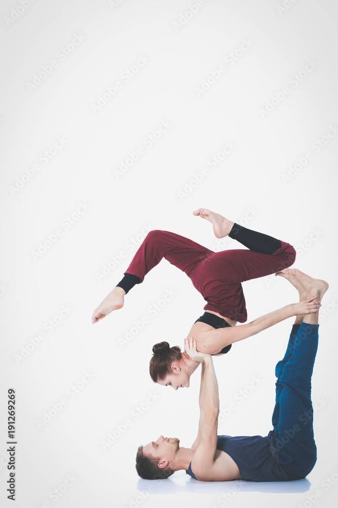 Young athletic couple practicing acroyoga. Balancing in pair Young athletic couple practicing acroyoga. Balancing in pair