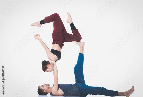 Young athletic couple practicing acroyoga. Balancing in pair