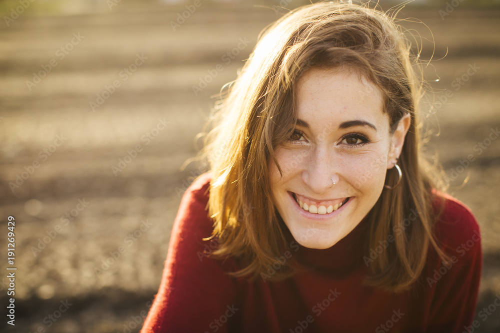 Young beautiful girl in the field. She wears a red sweater and jeans. Young beautiful girl in the field. She wears a red sweater and jeans.