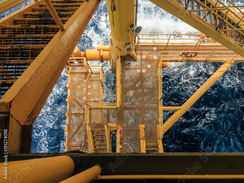 Offshore oil and gas platform at boat landing while the high wave in the sea hit the boat landing.