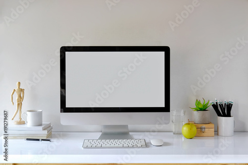 Mockup desktop Blank screen modern computer, coffee mug, house plant, pencils, puppet and office supplies.