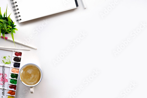 top view artist desk, coffee, notebook and brush.