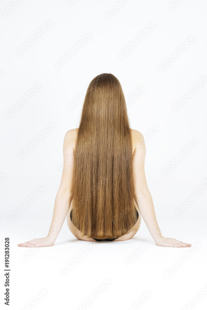 Naklejka premium fashion studio photo of beautiful young woman with luxurious long hair, natural color, back view, arms