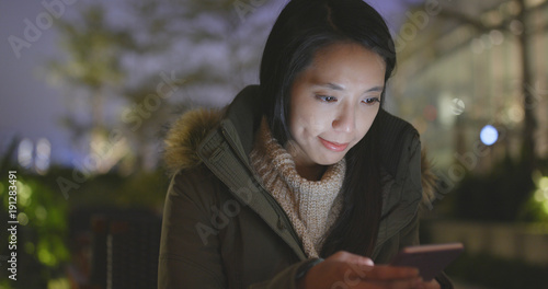 Business woman using mobile phone at night