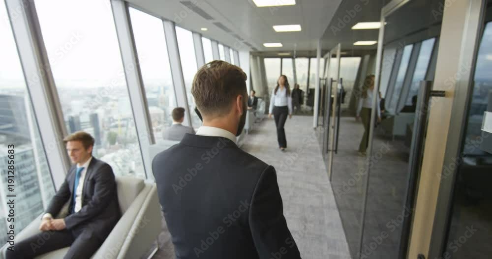 4K Successful businessman talking on phone & walking through modern London office. View from window shows London's famous skyline. Slow motion. 4K Successful businessman talking on phone & walking through modern London office. View from window shows London's famous skyline. Slow motion.