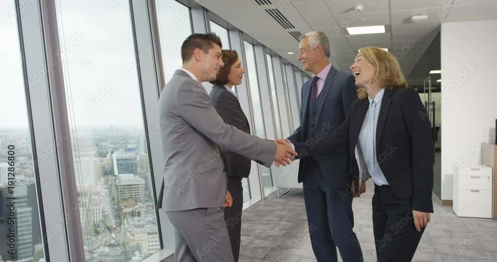 4K Smiling corporate business group meet & shake hands in modern city office. Slow motion