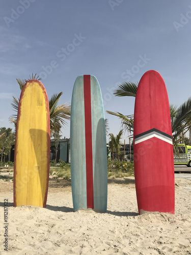 Photography Colorful surfboards stand on the beach.
