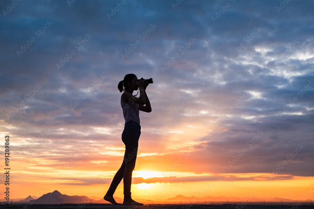 silhouette of Asian women photography with mountain at sunset .