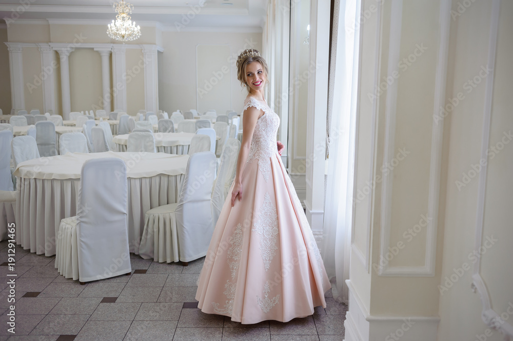 A beautiful woman in a pink wedding dress in a big festive hall A beautiful woman in a pink wedding dress in a big festive hall