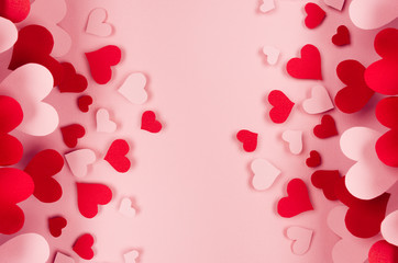Valentine day background of many different paper hearts on pink soft background. Copy space.
