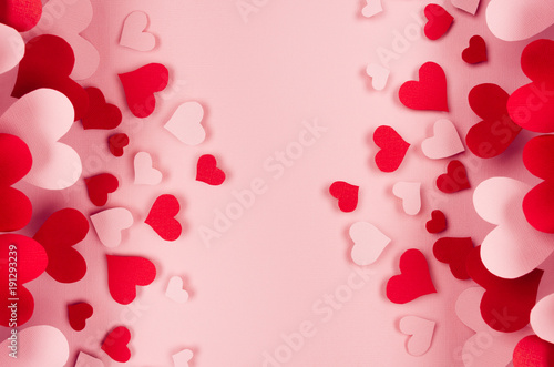 Valentine day background of many different paper hearts on pink soft background. Copy space.