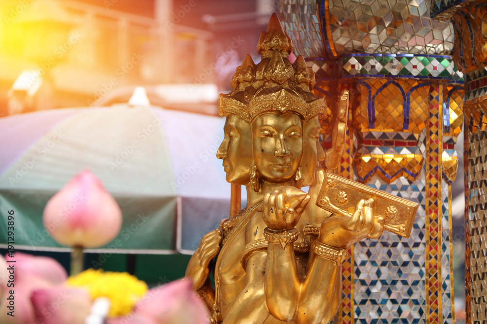Fototapeta premium Golden Hindu god Brahma statue be enshrined on altar. Beautiful Indian religion traditional lord sculpture. The creator god in Hinduism, who forms a triad with Vishnu and Shiva.