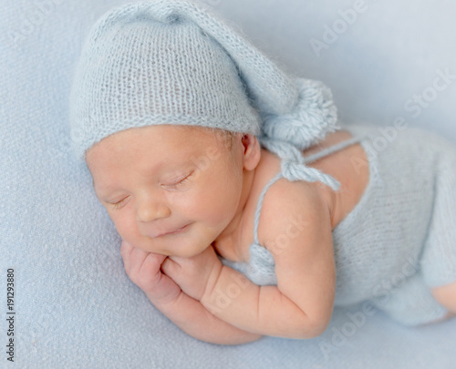 Smiling newborn baby boy sleeping peacefully.