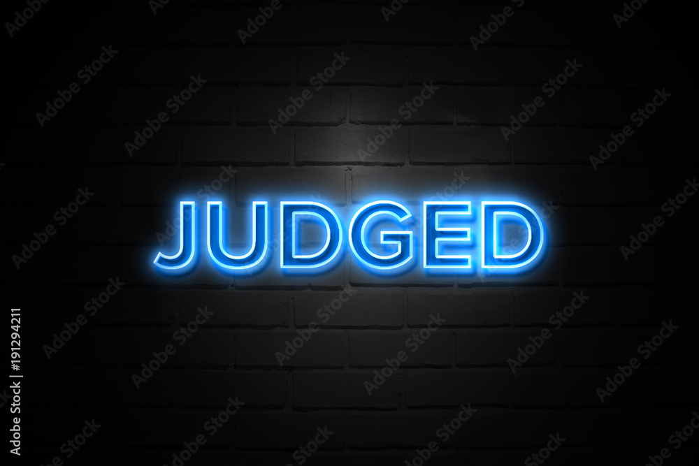 Judged neon Sign on brickwall