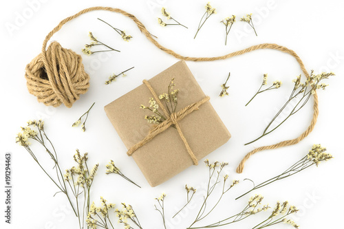 Brown gift boxes and rope with yellow limonium caspia flowers on white wood background 