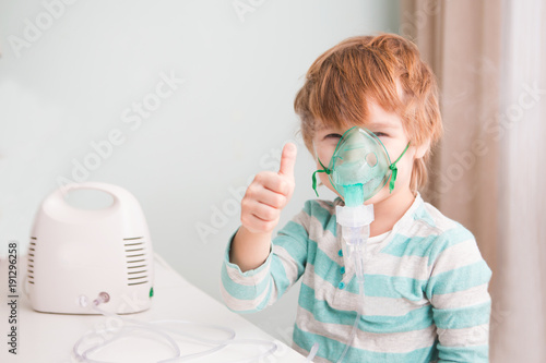 Little boy making inhalation with nebulizer at home. 
 photo