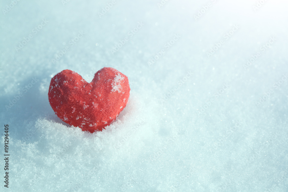 The red heart lies on the blue snow under the sun. Template for a holiday card for Valentine's Day.