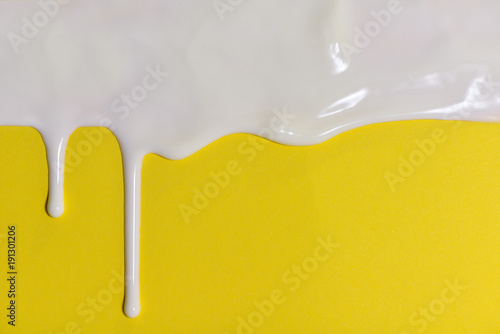 Thick white paint dripping down the yellow wall.