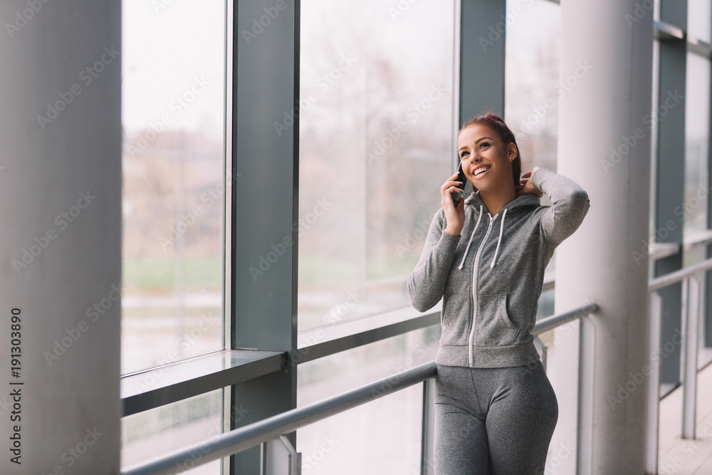 Woman in sport wear talking on mobile phone Woman in sport wear talking on mobile phone