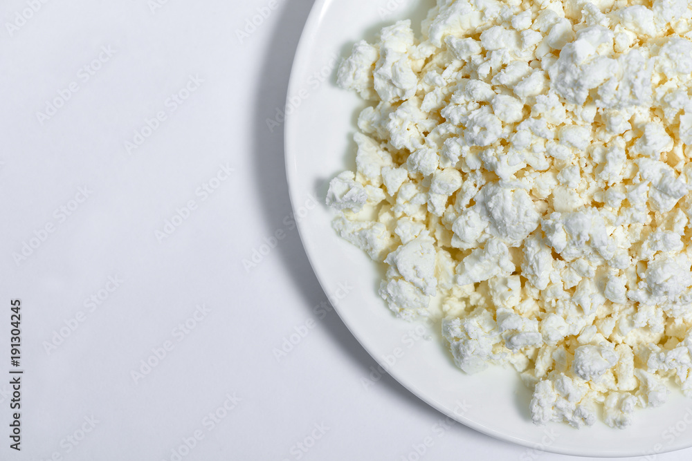A bowl of homemade cottage cheese on a white background.