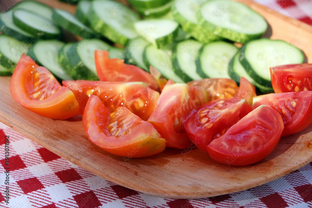 plateau with fresh organic tomatoes and cucumbers cut in pieces