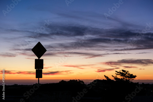 Road sign silhouette and colorful sunset