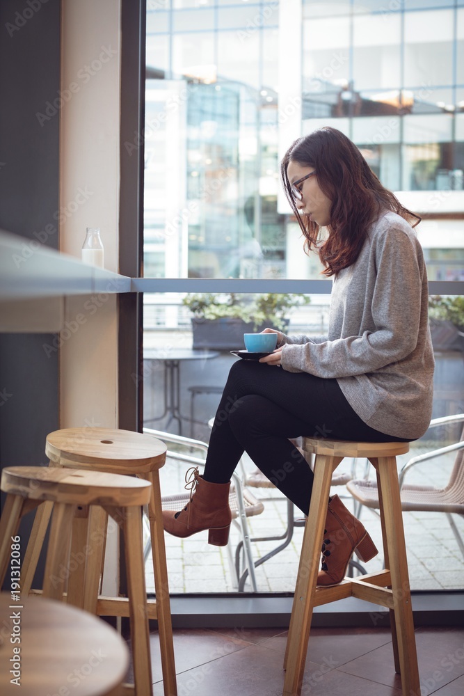 Thoughtful woman having coffee at table Thoughtful woman having coffee at table