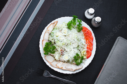 on a dark fabric background iceberg lettuce, with quail eggs, flat lay photo