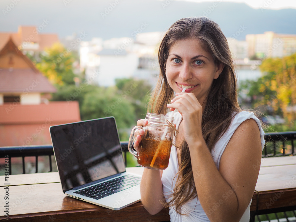 digital nomad woman with laptop and drink on a rooftop digital nomad woman with laptop and drink on a rooftop