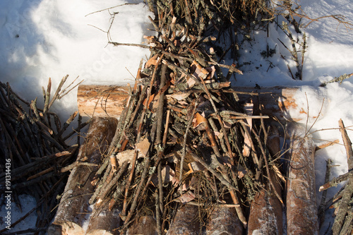 Bushcraft campfire in deep snow, finished pyramid of small and medium-sized wood,  birch bark and tree resin, ready to light the fire photo