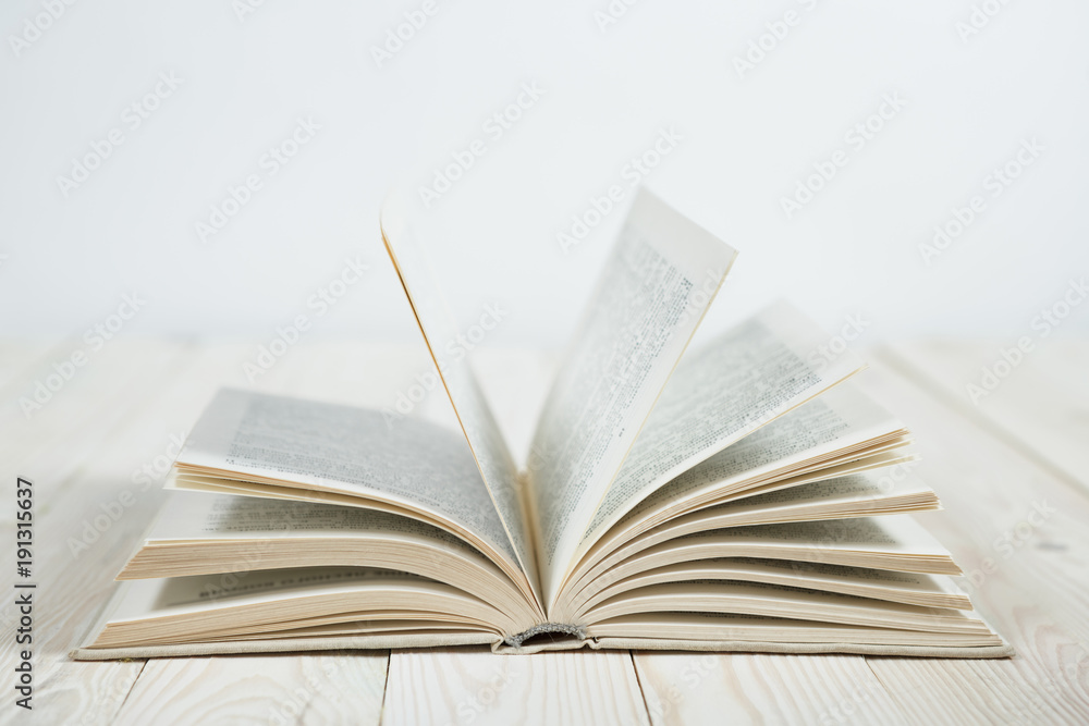 Obraz premium Open of pastel colorsbooks hardback on wooden table.
