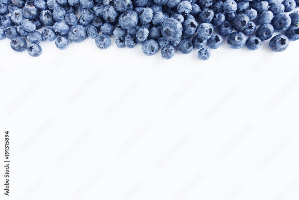 Blue food on a white background. Ripe blueberries at border of image with copy space for text. Various fresh summer berries on white background. Top view. Blue food on a white background. Ripe blueberries at border of image with copy space for text. Various fresh summer berries on white background. Top view.