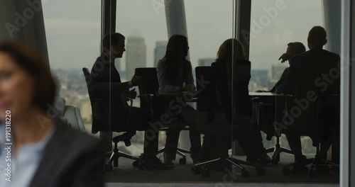 4K Laid back corporate business team laughing & joking in boardroom meeting in city office. Slow motion.
