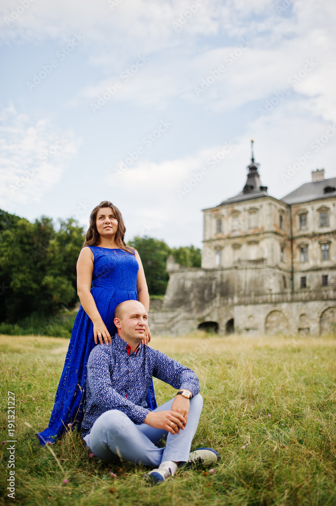 Lovely couple in love against old castle. Girl in blue dress. Lovely couple in love against old castle. Girl in blue dress.
