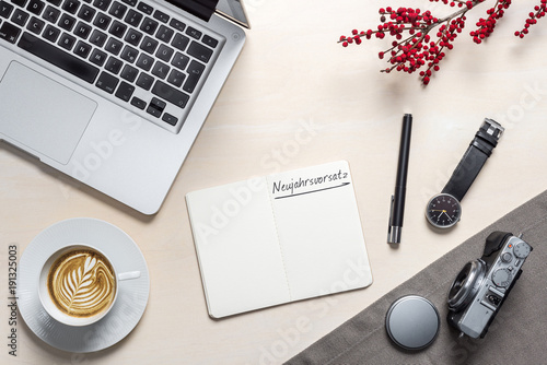 Neujahrsvorsatz auf Notizblock auf Fotografen Schreibtisch von oben